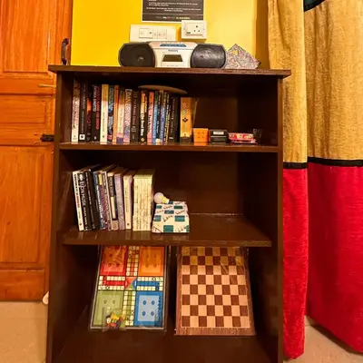 a book shelf filled with books and games at Rastafari - The Backpackers Hostel in Ooty