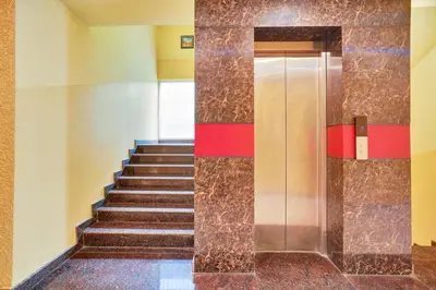 a staircase in a building with a elevator at Super Collection O Kushal Nagar Near KSRTC Bus Stand in Madikeri