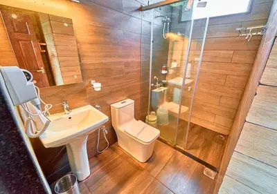 a bathroom with a toilet and a sink and a shower at AJ Gable Clouds Ooty by VOYE HOMES - Serene Stay Near Avalanche Emerald Lake in Ooty