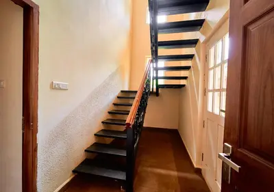 a spiral staircase in a house with a window at AJ Gable Clouds Ooty by VOYE HOMES - Serene Stay Near Avalanche Emerald Lake in Ooty