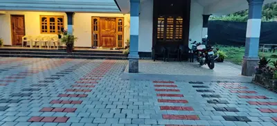 a house with a motorcycle parked in front of it at Bridge Point Home Stay in Kushālnagar