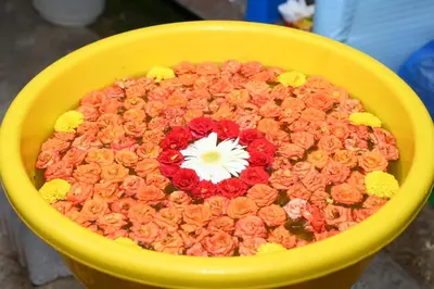 a yellow bowl of flowers with a white flower in it at Bridge Point Home Stay in Kushālnagar