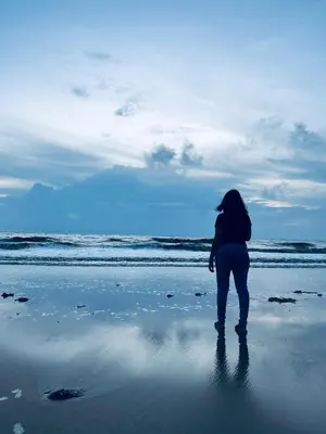a woman standing on the beach looking at the ocean at Thira Beach Home in Thanniyam
