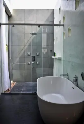 a bathroom with a tub and a glass shower at Thira Beach Home in Thanniyam