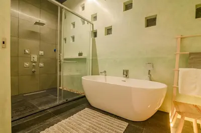 a bathroom with a large tub and a shower at Thira Beach Home in Thanniyam