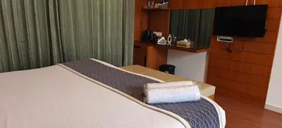 a hotel room with a bed and a flat screen tv at S R Private Residence in Mysore