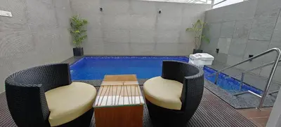 a swimming pool with two chairs and a table at S R Private Residence in Mysore
