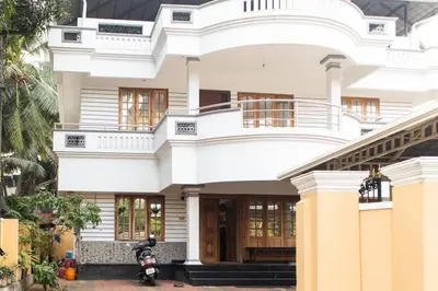 a house with a motorcycle parked in front of it at Jaalakam Retreat in Trichūr