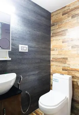 a bathroom with a white toilet and a sink at Jaalakam Retreat in Trichūr