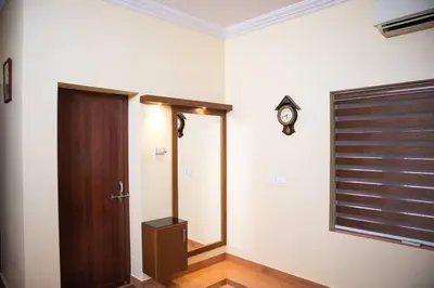 a hallway with a door and a clock on the wall at Jaalakam Retreat in Trichūr
