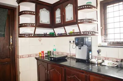 a kitchen with a counter with a coffee maker on it at Jaalakam Retreat in Trichūr