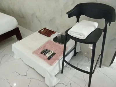 a black chair sitting next to a table with a towel at M Grand Stay in Coimbatore