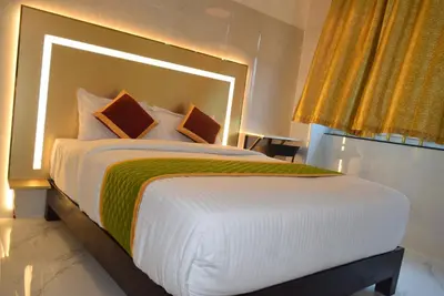 a bedroom with a large bed with a large headboard at M Grand Stay in Coimbatore