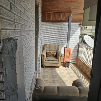 a living room with a couch and a chair at MysticGreens Guest House! in Kushālnagar