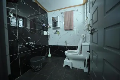 a bathroom with a white toilet and a sink at MysticGreens Guest House! in Kushālnagar