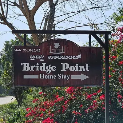 a sign for a bridge point home stay at MysticGreens Guest House! in Kushālnagar