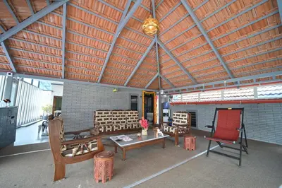 a living room with chairs and a table in a building at MysticGreens Guest House! in Kushālnagar