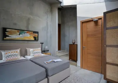 a bedroom with two beds and a wooden door at LohonoStays Villa Amani 8A in Coonoor