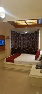 a bedroom with a bed and a television in it at Quick Sort Residency in Ooty