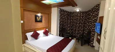 a bedroom with a bed with red pillows at Quick Sort Residency in Ooty