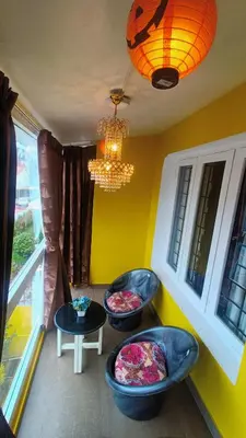 a room with three ottoman chairs in front of a window at Quick Sort Residency in Ooty