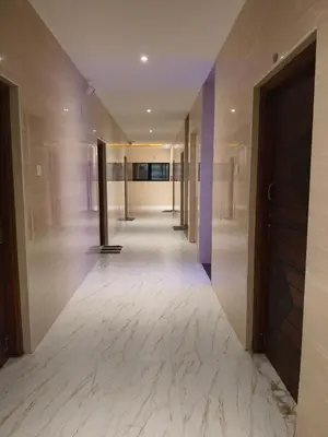 a hallway with white marble floors and a door at Kandhaguru Residency in Palani