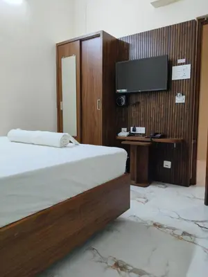 a bedroom with a bed and a flat screen tv at Kandhaguru Residency in Palani