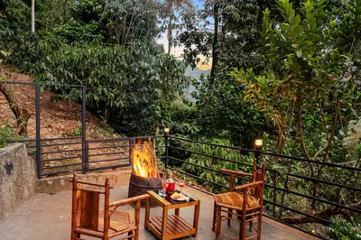 a couple of chairs and a table on a balcony at The Cove Lakkidi in Vythiri