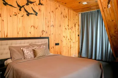 a bed in a room with a wooden wall at The Cove Lakkidi in Vythiri