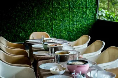 a long table with plates and bowls of food on it at The Cove Lakkidi in Vythiri