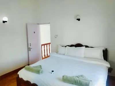 a bedroom with a large white bed with two pillows at Teyt's White Home - 3 bedroom Villa in Ooty