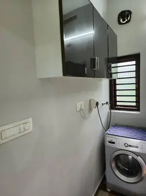 a kitchen with a washing machine and a microwave at Padua Building in Irrity
