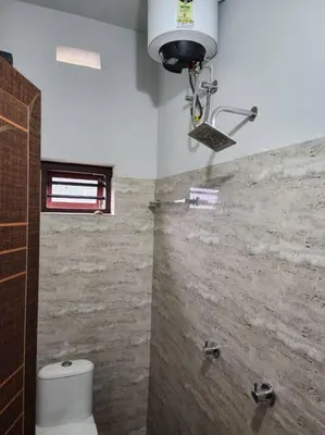 a bathroom with a toilet and a light on the ceiling at Padua Building in Irrity