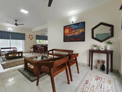 a living room with a table and a mirror at 7 Elysee Homestay - Onyx - Premium 3BHK Family Flat in Trichūr