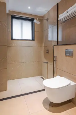 a bathroom with a toilet and a glass shower at Royal Embassy in Erode