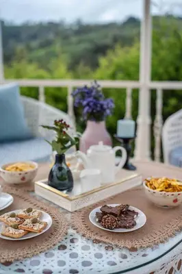 a table with plates of food on top of a table at LohonoStays Villa Lansdowne in Coonoor
