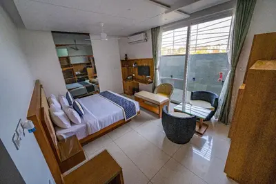 a hotel room with a bedroom with a bed and a window at S R Pool Suites in Mysore