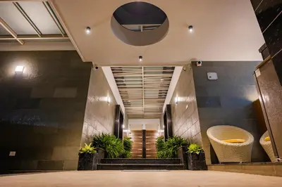 a lobby of a building with stairs and plants at S R Premium Suites in Mysore