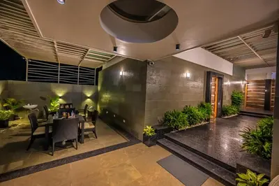 a restaurant with a table and chairs and plants at S R Premium Suites in Mysore