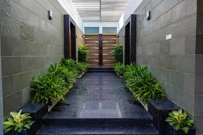 a hallway in a building with a door and plants at S R Premium Suites in Mysore
