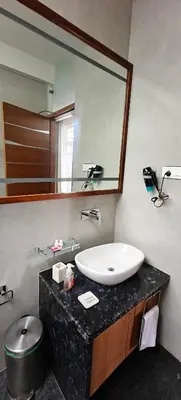 a bathroom with a sink and a mirror at S R Premium Suites in Mysore