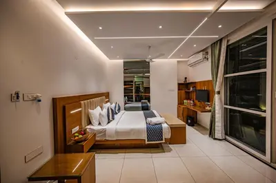 a bedroom with a bed and a desk in a room at S R Spa Suites in Mysore