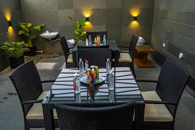 a dining room with a table with chairs and a sink at S R Spa Suites in Mysore