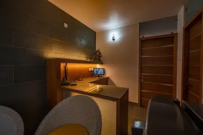 a bathroom with a sink and a desk with chairs at S R Spa Suites in Mysore