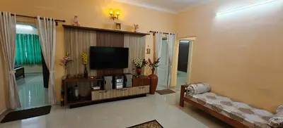 a living room with a television and a couch at S R Villa Mysore in Mysore
