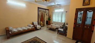 a living room with a couch and chairs in a room at S R Villa Mysore in Mysore