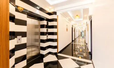 a hallway with a black and white checkered floor at Treebo Premium Cochin Airport, 5 min From Cochin Airport in Ernakulam