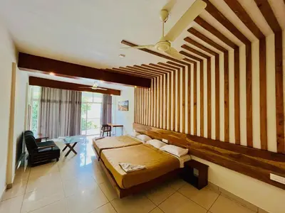 a bedroom with a bed with a wooden wall at Heaven Hills resorts in Vythiri