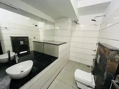 a white bathroom with a sink and a toilet at Heaven Hills resorts in Vythiri
