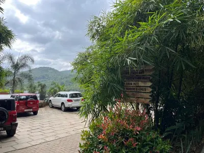 a parking lot with parked cars and a sign at Heaven Hills resorts in Vythiri